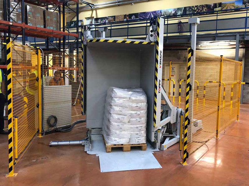 Pallet Flipper with safety barriers in a warehouse