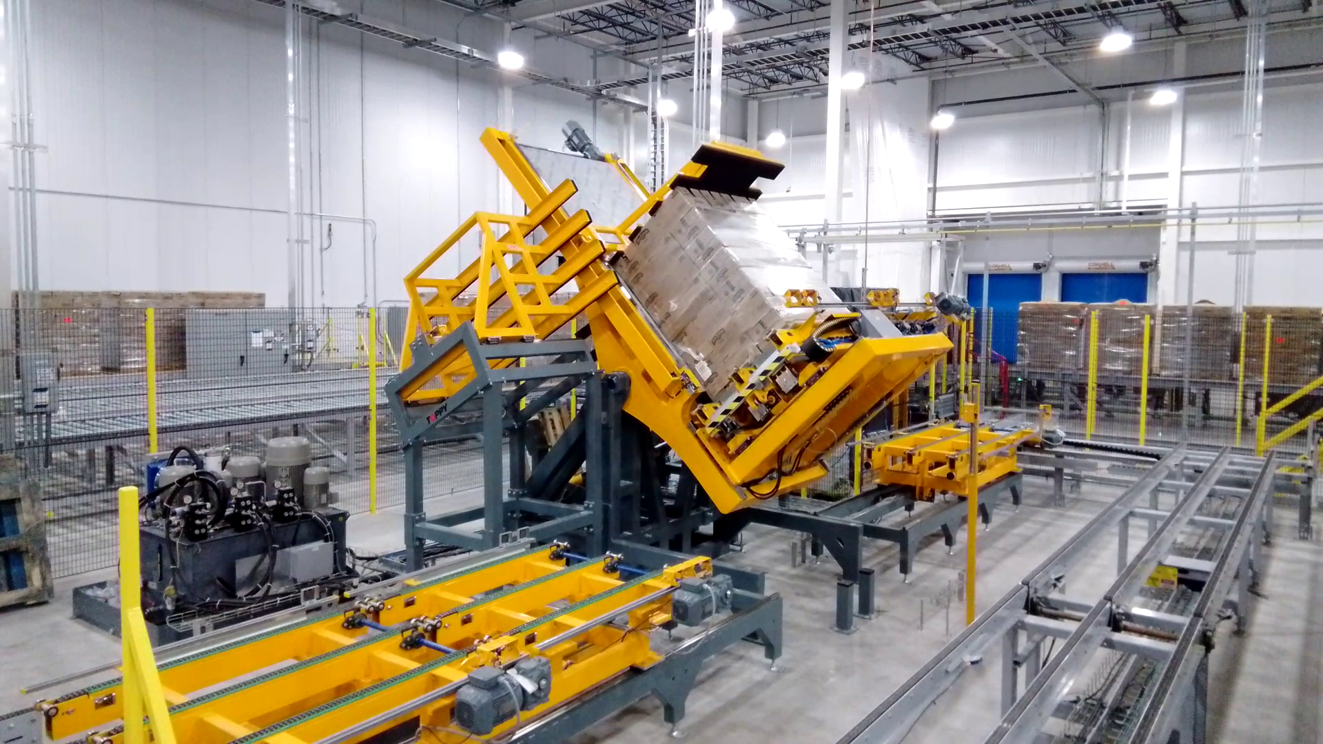 Pallet inverter lifting a loaded pallet during warehouse operation